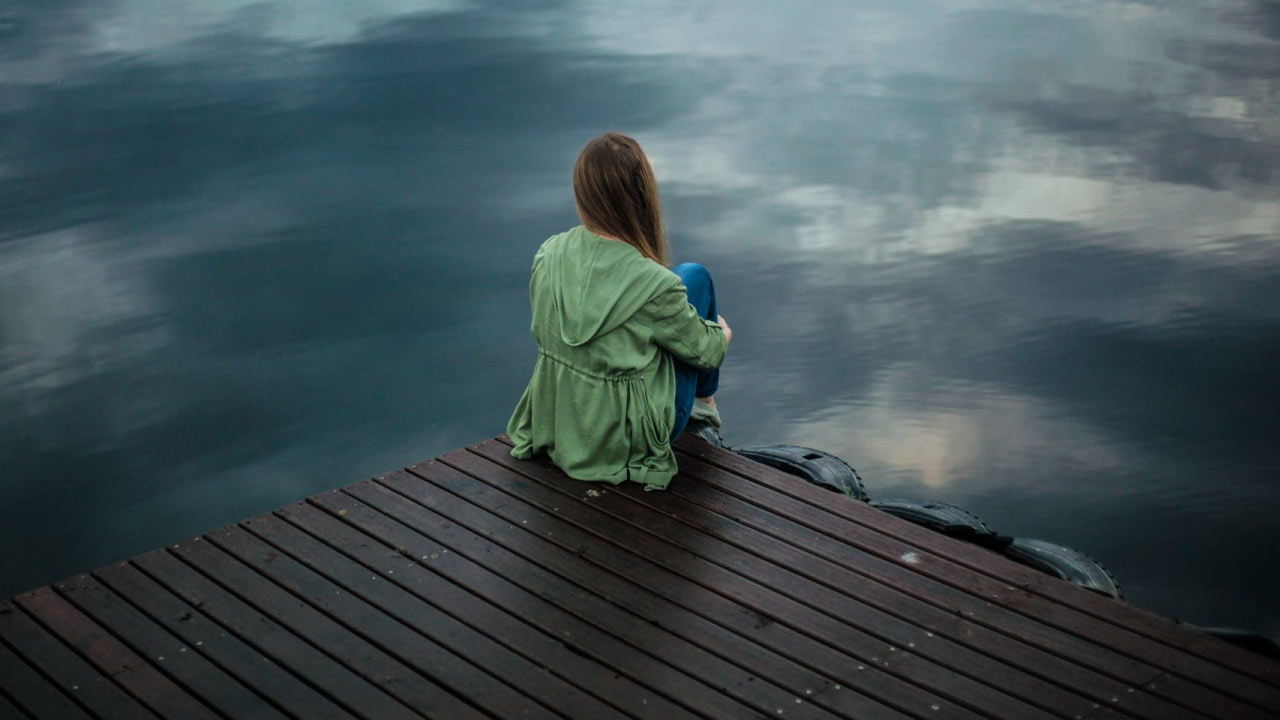 girl sitting at dock with anxiety that could use hemp oil