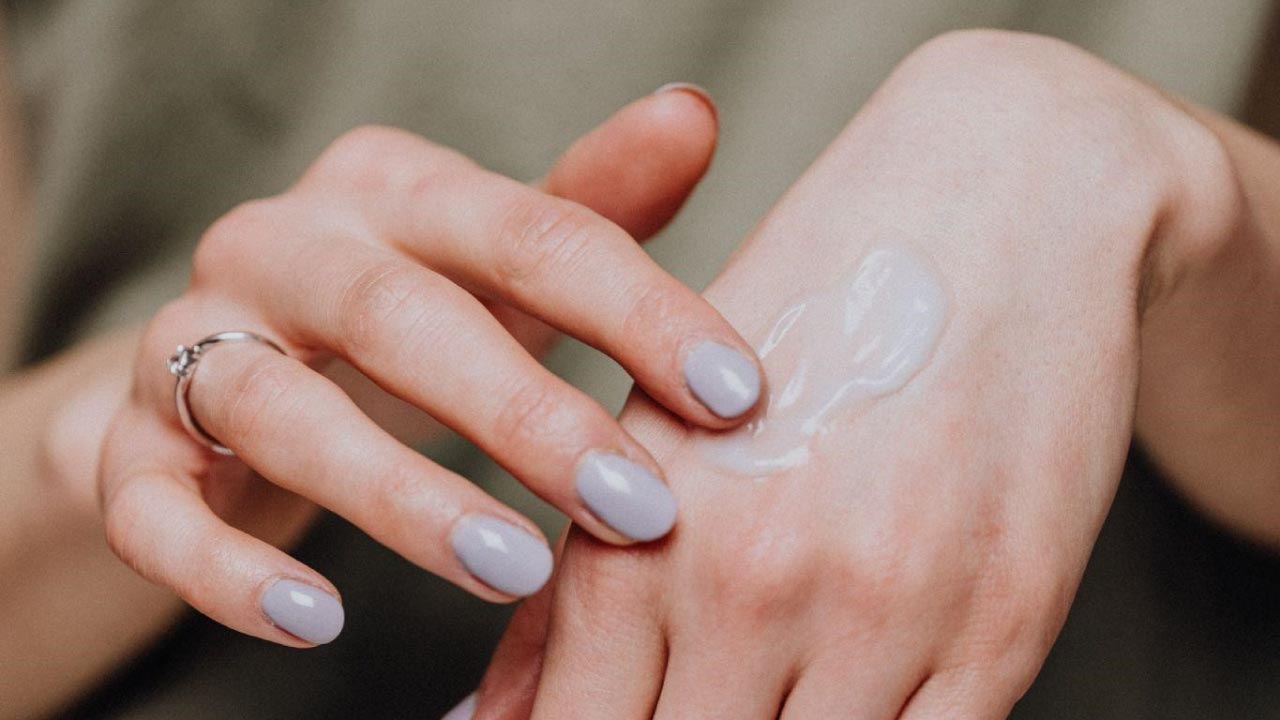 Woman rubbing cbd cream on her skin