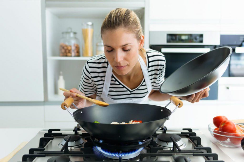 woman smelling what she's cooking for diet