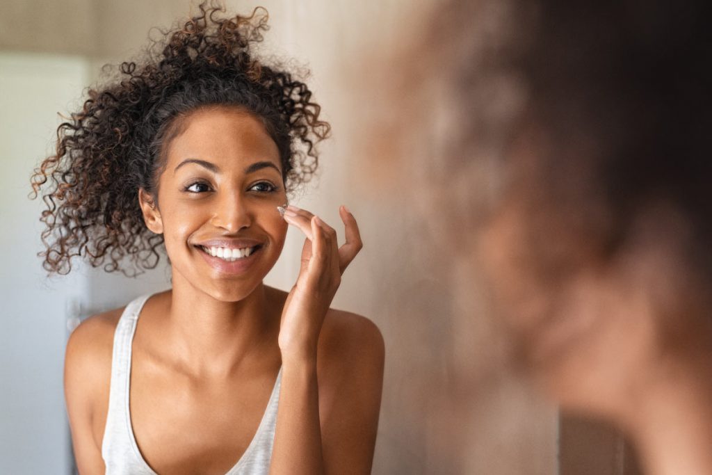 woman putting on tea tree oil for skin and nails